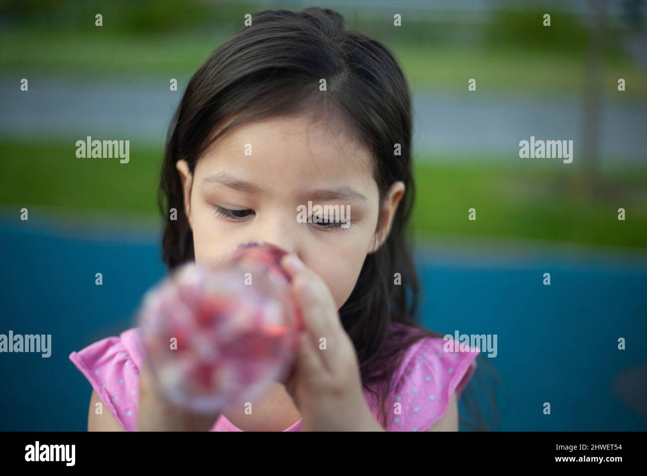 Girl drinks water. Preschooler quenches her thirst. Child holds bottle