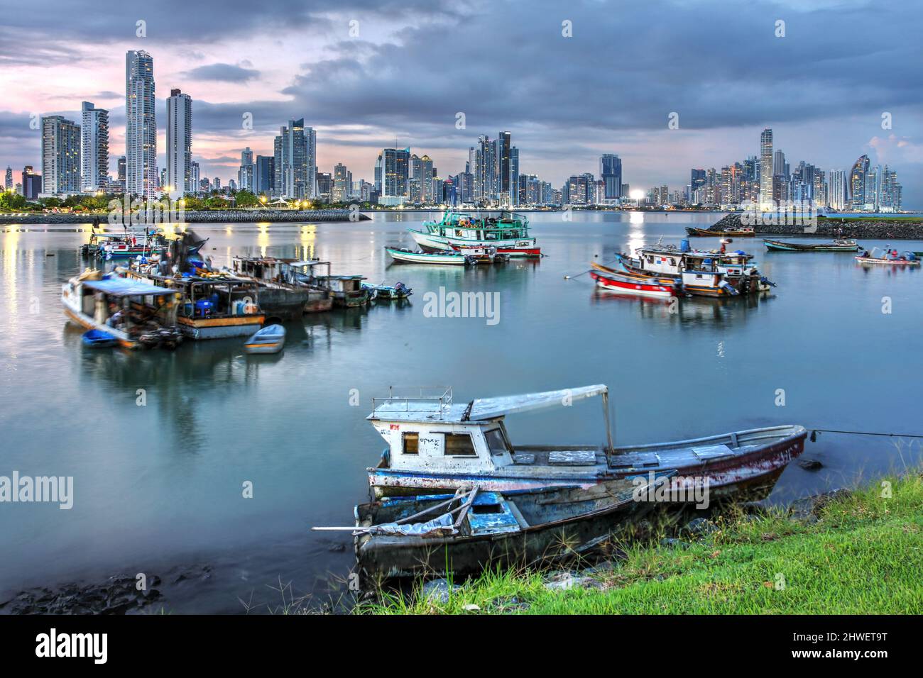 Local fishing boats against the futuristic skyline of Panama City Stock Photo