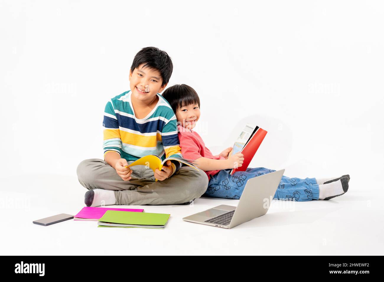 Portrait of Happy asian boys, Brother on floor with laptop and books ...
