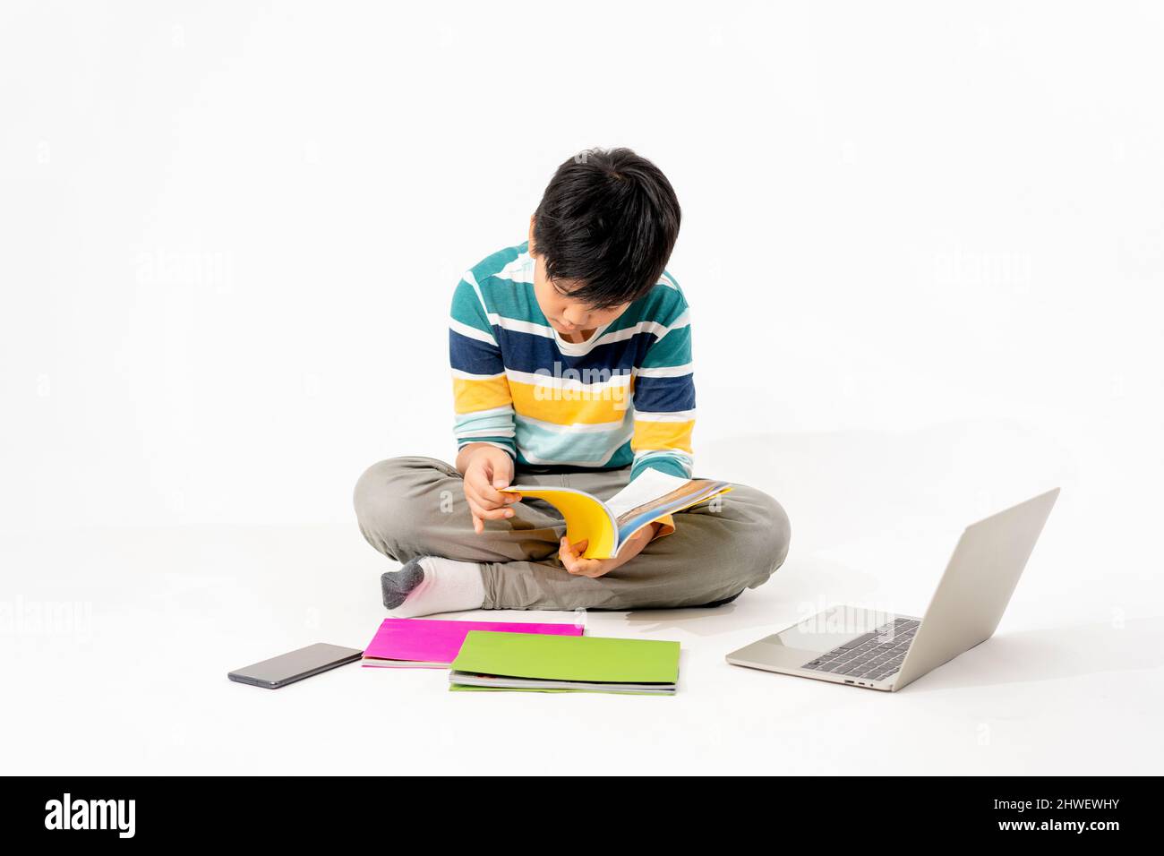 Portrait of Happy asian boy on floor with laptop and books isolated on ...