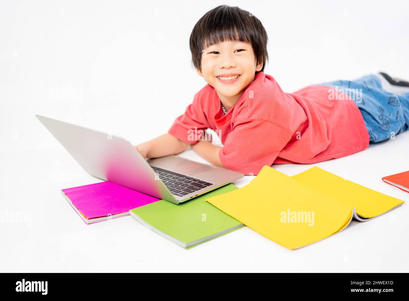 Portrait of Happy asian boy on floor with laptop and books isolated on ...