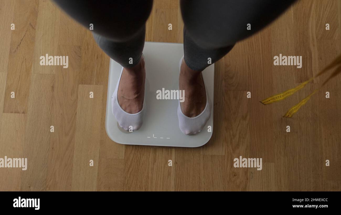 Woman Measuring Body Weight On Weighing Scale At Home Stock Photo Alamy