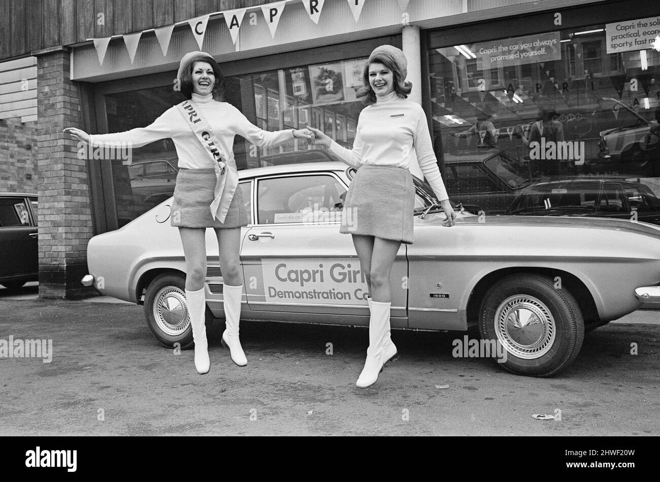 The launch of The Ford Capri Mk1.Picture taken at a showroom of car dealer Dennis J Hands in the Reading area, and shows the new Ford Capri on the forecourt, and the promotion ladies enjoying the day.  The Ford slogan, used as part of the promotion was, 'the car you have always promised yourself'  The first Ford Capri was introduced in January 1969 at the Brussels Motor Show, with sales starting the following month. The intention was to reproduce in Europe the success Ford had had with the North American Ford Mustang; to produce a European pony car  Picture taken 14th February 1969The launch o Stock Photo