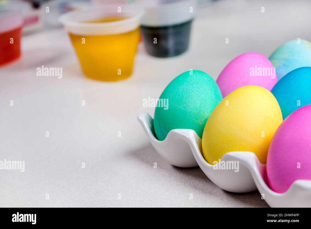 Bright colorful painted Easter eggs lying on white table. Traditional decoration Stock Photo
