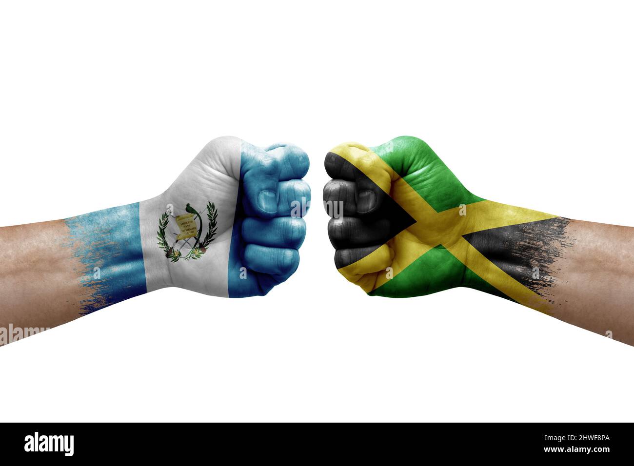 Two hands punch to each others on white background. Country flags painted fists, conflict crisis concept between guatemala and jamaica Stock Photo