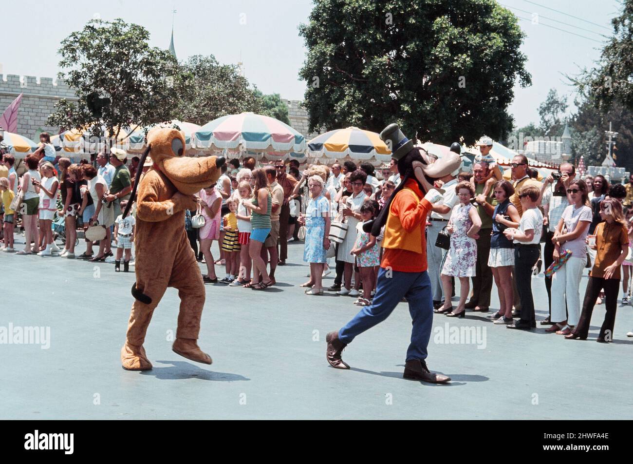 Scenes at the Disneyland theme park in Anaheim, California, United States. Disney canine characters Pluto and Goofy during the Main Street parade. June 1970. Stock Photo