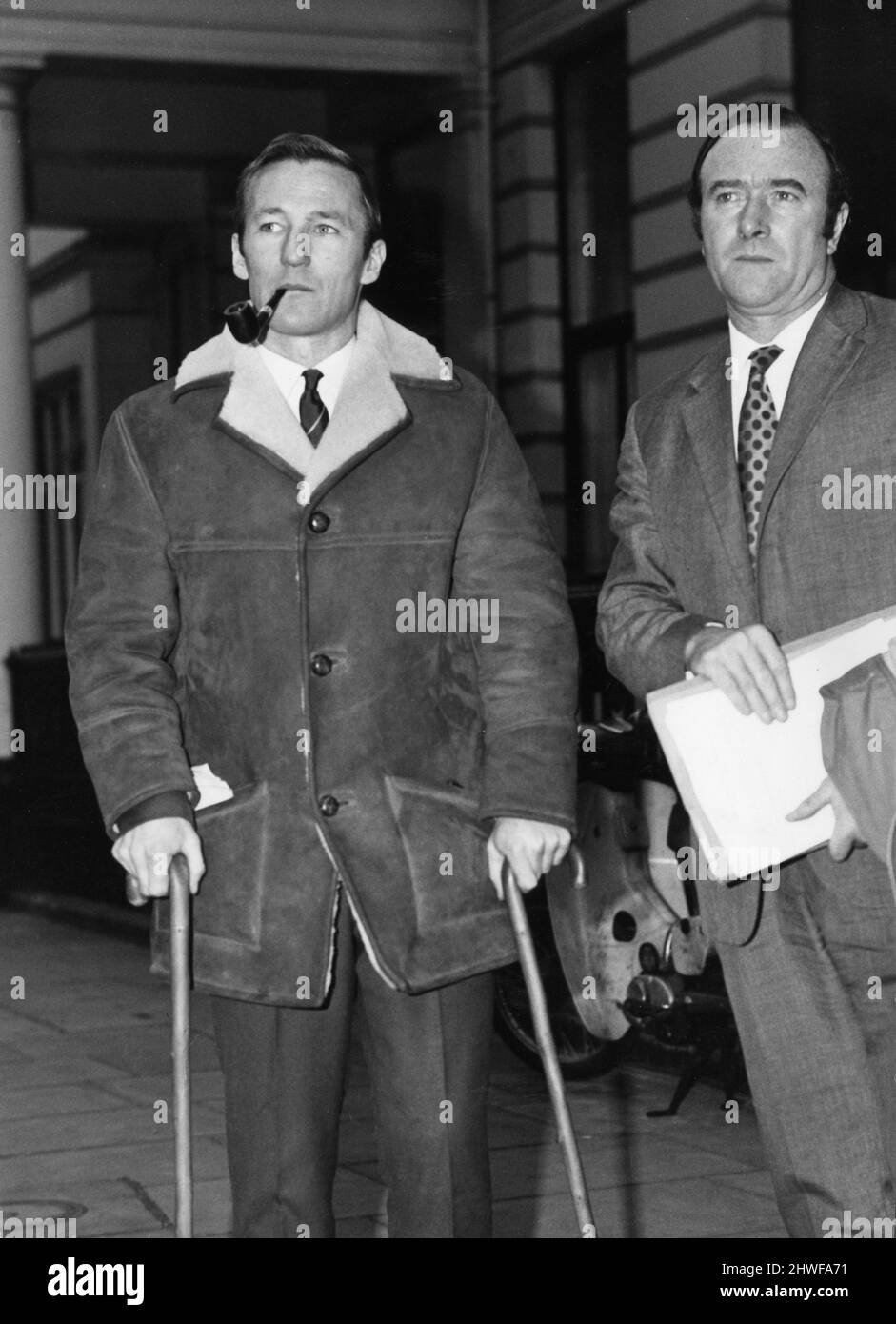 Peter Dobing (left) leaves FA headquarters after a disciplinary hearing with boss Tony Waddington, 16th December 1970.  Dobing on crutches as he had recently broken his leg in a league fixture. *** Local Caption *** Football Player Football Manager Stock Photo