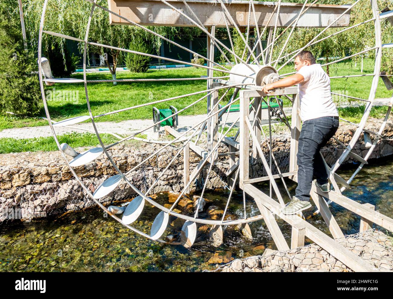 Water wheel installed on the city river Qoushkar in Shymkent, Kazakhstan, Central asia Stock Photo