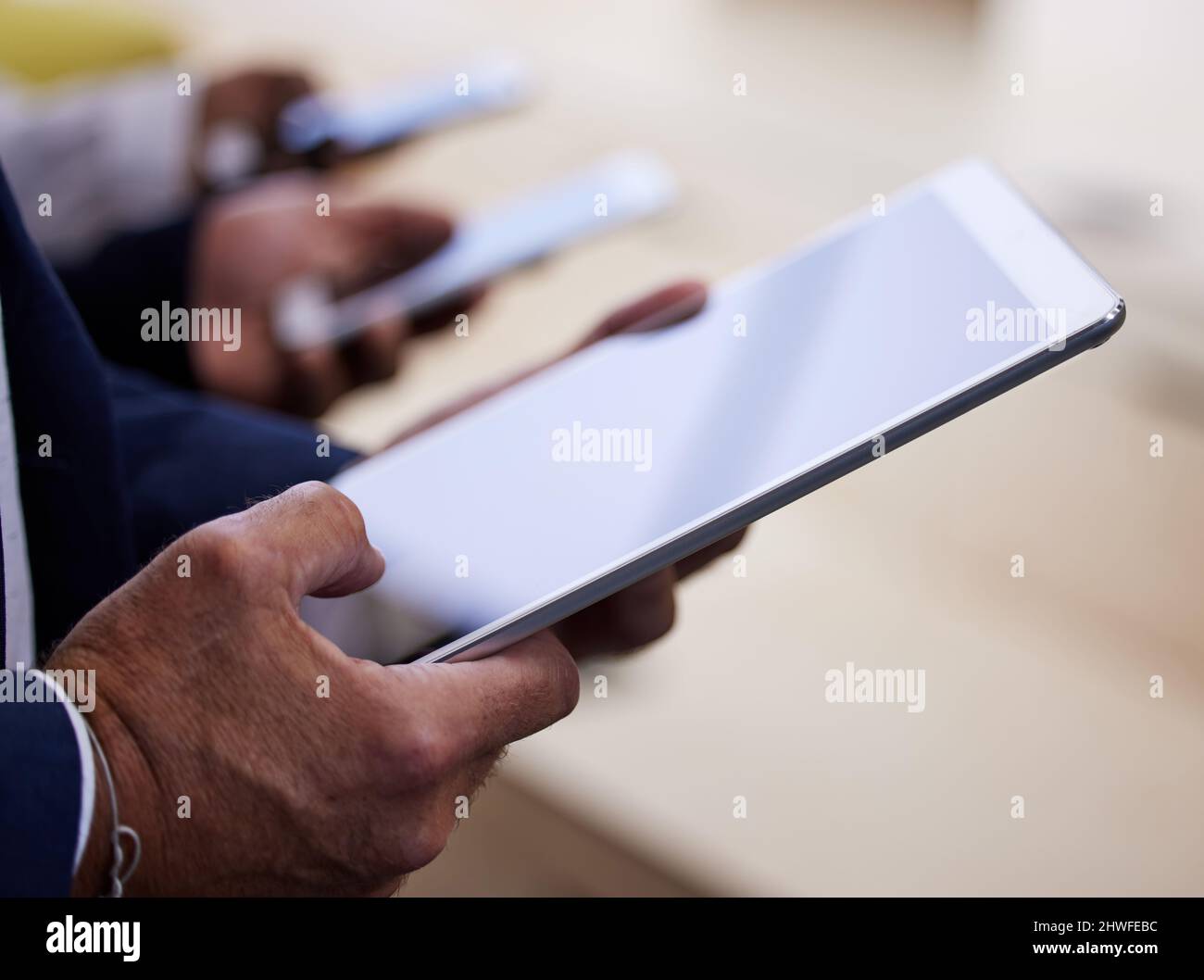 Our new brief just came in. Cropped shot of an unrecognizable group of businesspeople standing together in a circle and using technology. Stock Photo