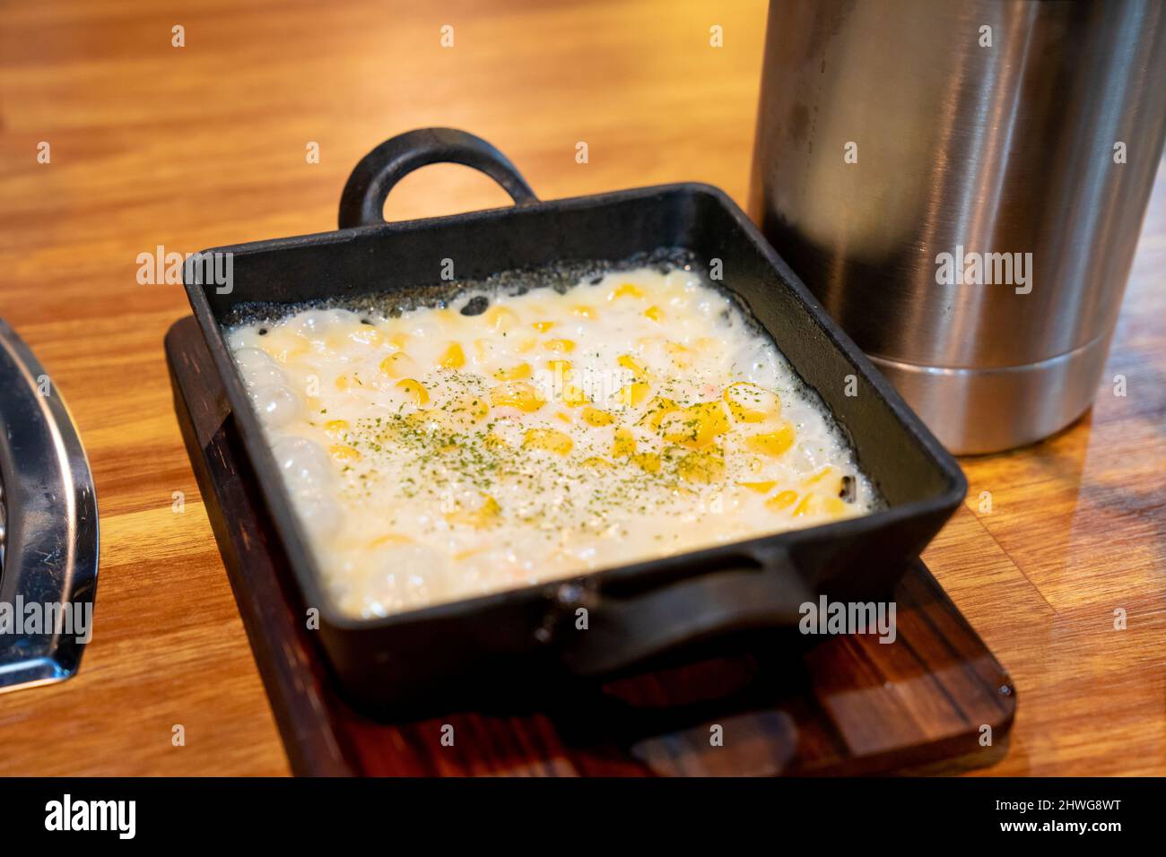 Korean style corn, cheese and mayonnaise, in a black pot, taken in a