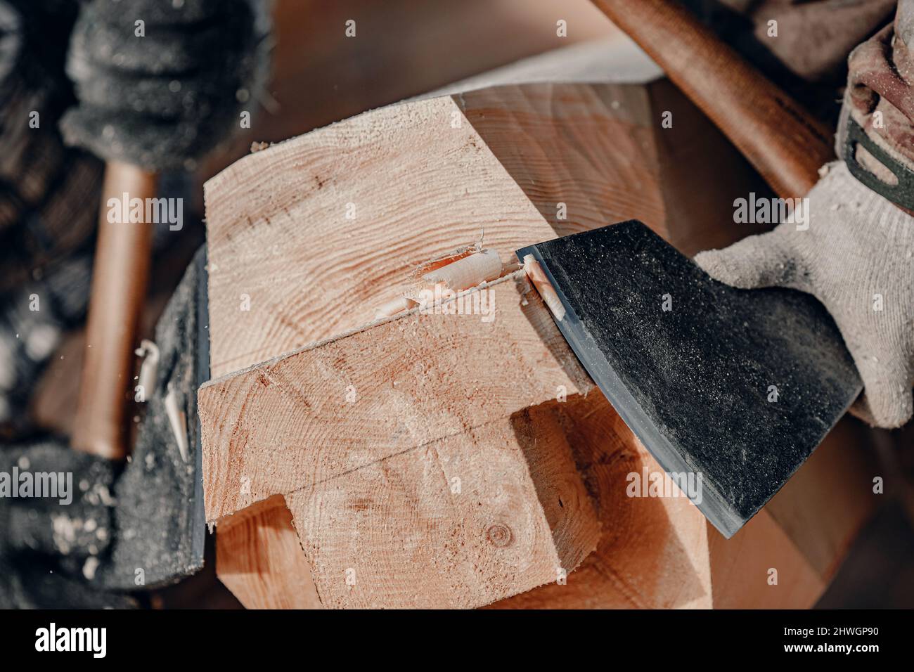 Carpenter with axe working with log wooden. Woodwork job, house frame building Stock Photo Alamy