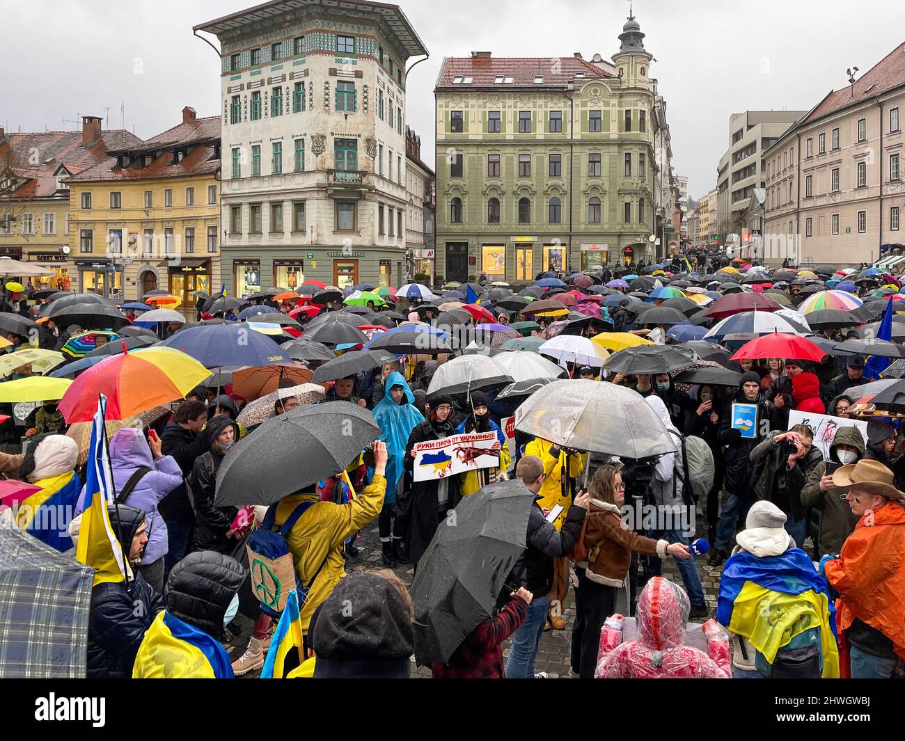 Large crowd of people with Ukrainian flags and posters gathered for a peaceful protest against the war in Ukraine. Journalists and correspondents Stock Photo