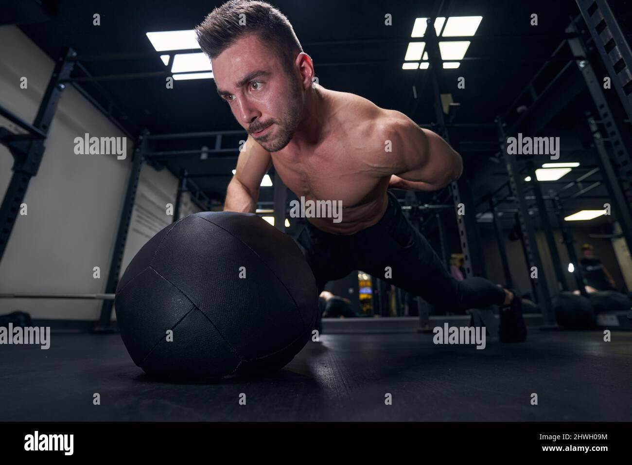Concentrated male person pushing up from ball Stock Photo Alamy