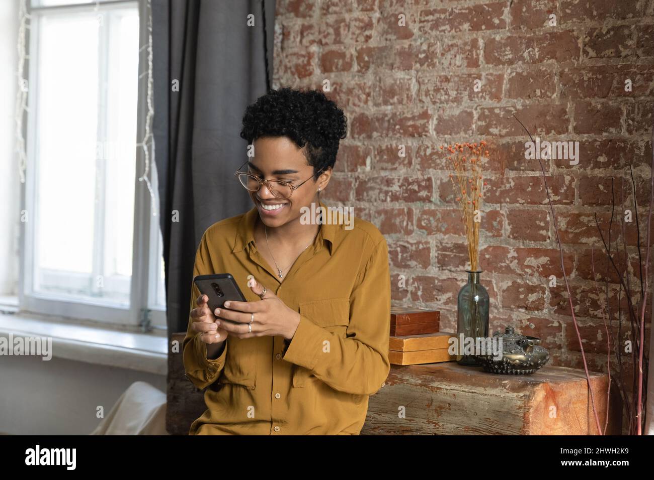 Joyful young African American cellphone user woman using virtual app ...