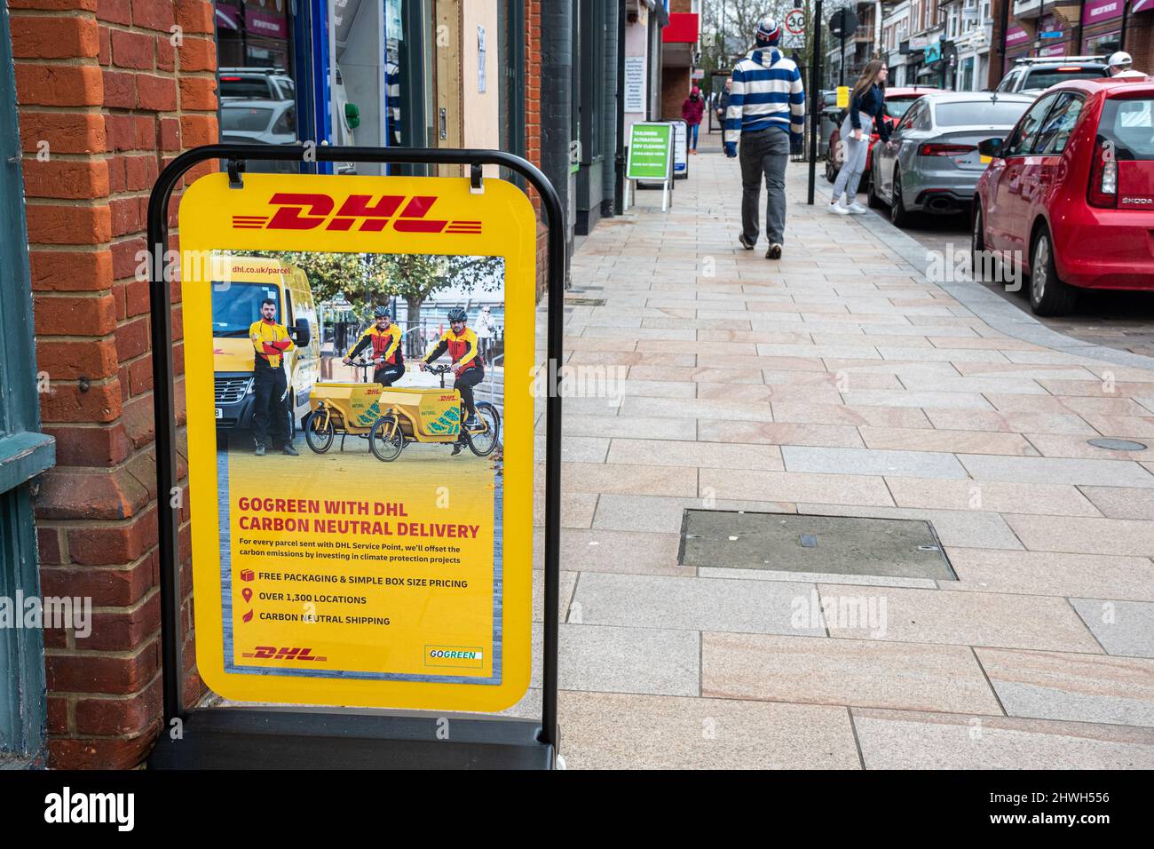 DHL sign or A-board advertising their Go Green with DHL carbon neutral delivery scheme, Camberley High Street, Surrey, UK Stock Photo