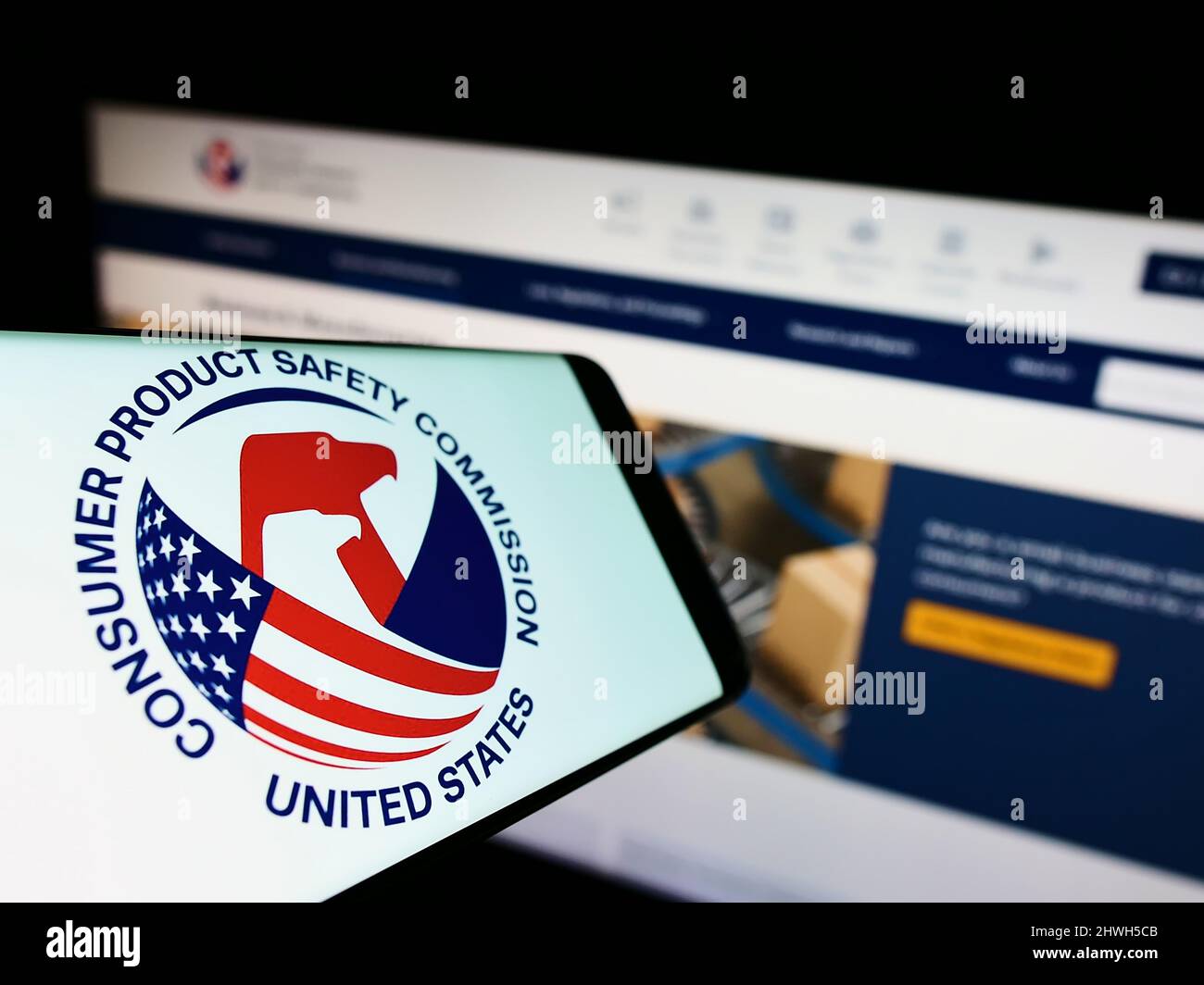 Smartphone with logo of United States Consumer Product Safety Commission (USCPSC) on screen in front of website. Focus on center of phone display. Stock Photo