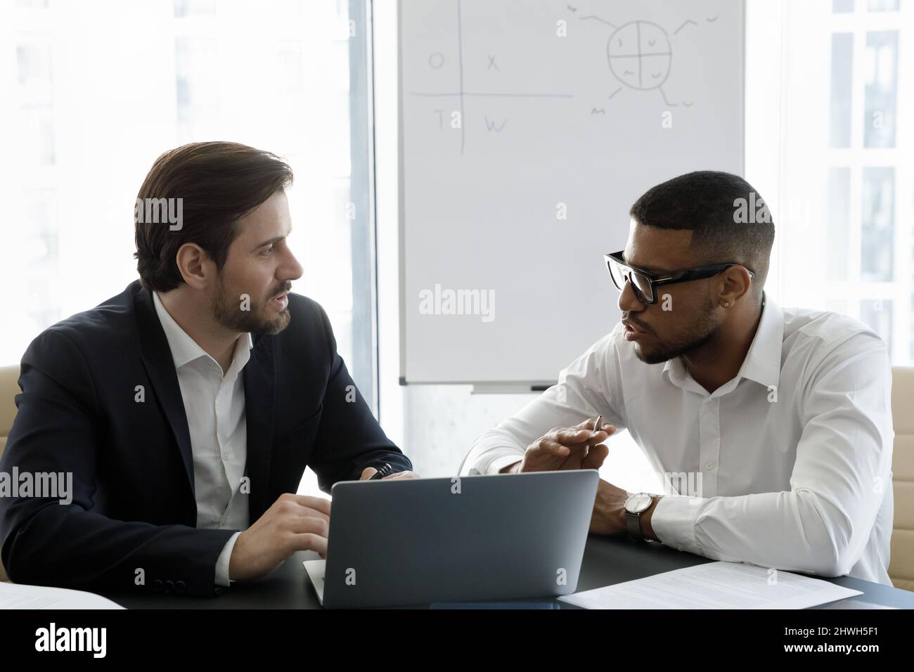 Happy focused young multiracial employees working on computer. Stock Photo