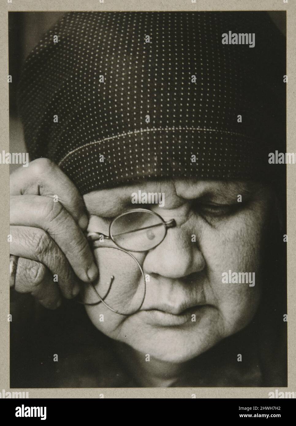 Portrait of the  Artist’s Mother (Olga Jedokimovna Rodchenko. The Mother. Reads a Magazine through one lens, in a headscarf. Moscow), from The Alexander Rodchenko Museum Series Portfolio, Number 1: Classic Images.  Artist: Alexander Rodchenko, Russian, 1891–1956Printer: Alexander Lavrentiev, Russian, born 1954 Stock Photo