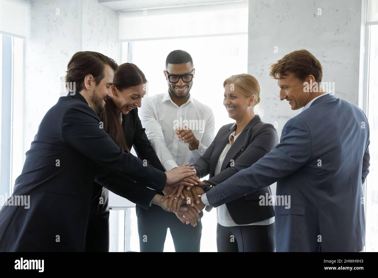 Happy motivated diverse business people showing power of teamwork. Stock Photo