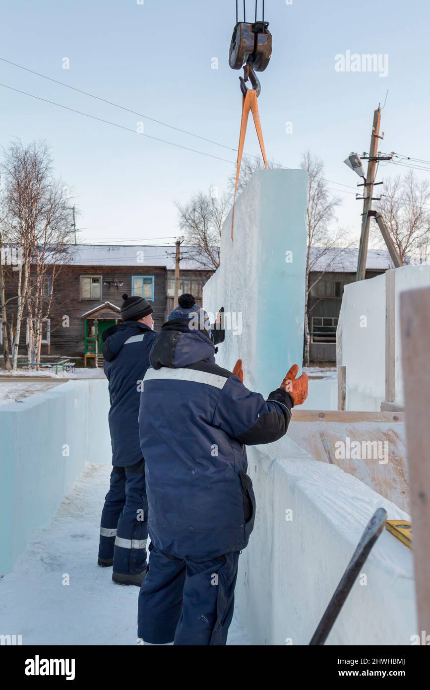Installers adjust and install another ice block to the overall ...