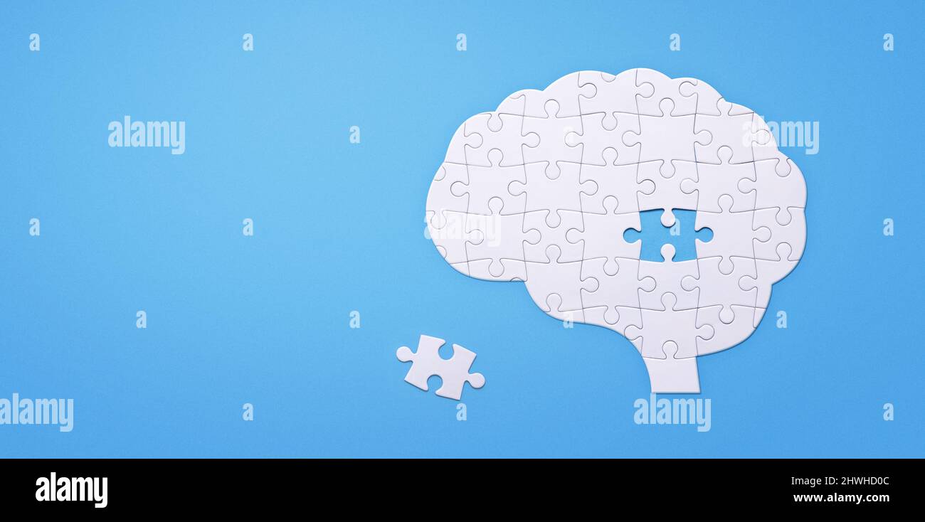 Jigsaw puzzle in shape of human brain isolated on blue background Stock Photo