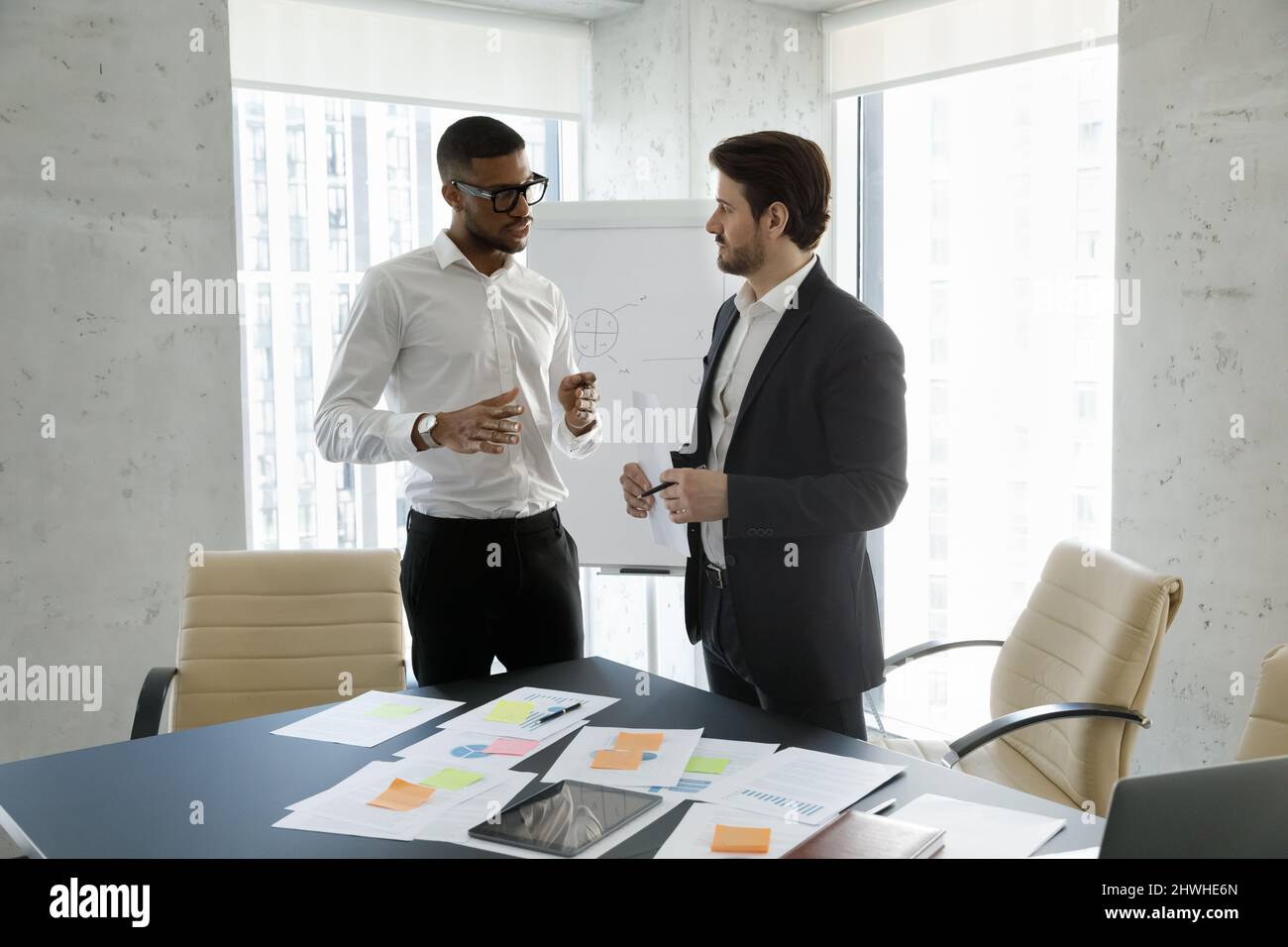 Focused multiracial employees discussing working issues in office. Stock Photo
