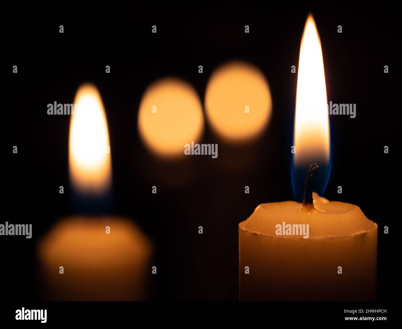 Two candles lit on the sides and in the middle their reflection of