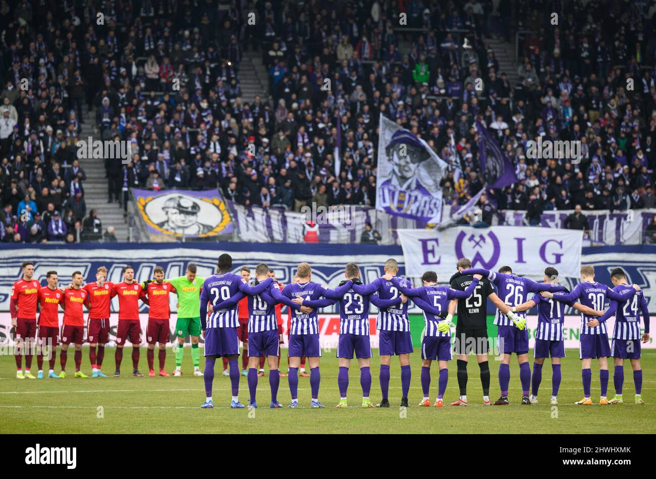 Aue, Germany. 06th Mar, 2022. Soccer: 2nd Bundesliga, FC Erzgebirge Aue - Jahn  Regensburg, Matchday 25, Erzgebirgsstadion. Both teams stand at the center  circle for a minute's silence in memory of the