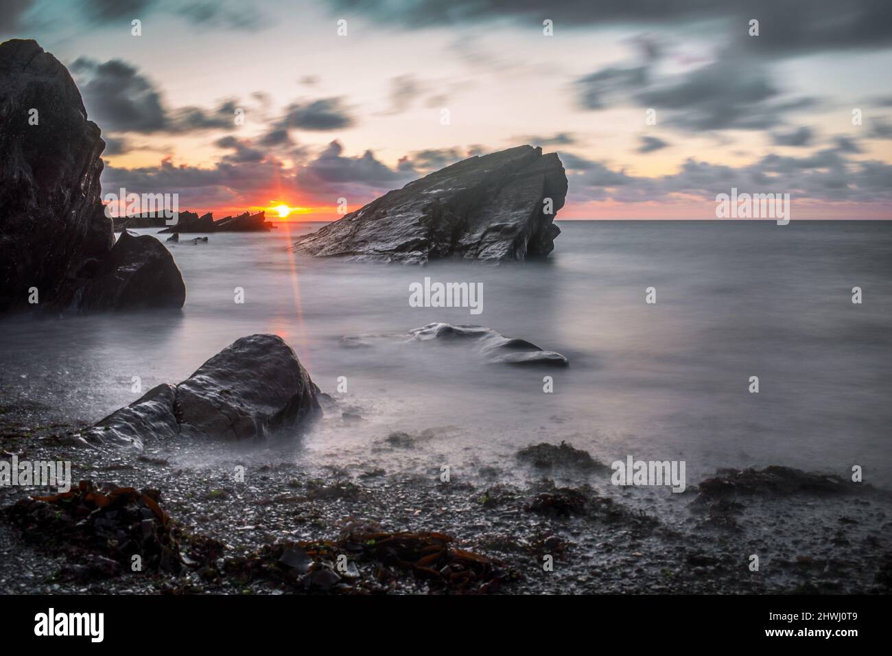 Different planet sunset - beach with huge rocks Stock Photo