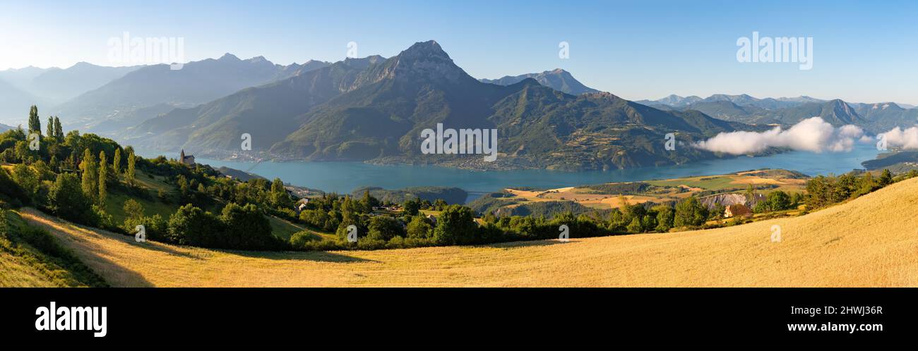 Summer panoramic view of Serre-Poncon Lake with Grand Morgon Peak and Savines-le-Lac village. Hautes-Alpes (Alps). France Stock Photo