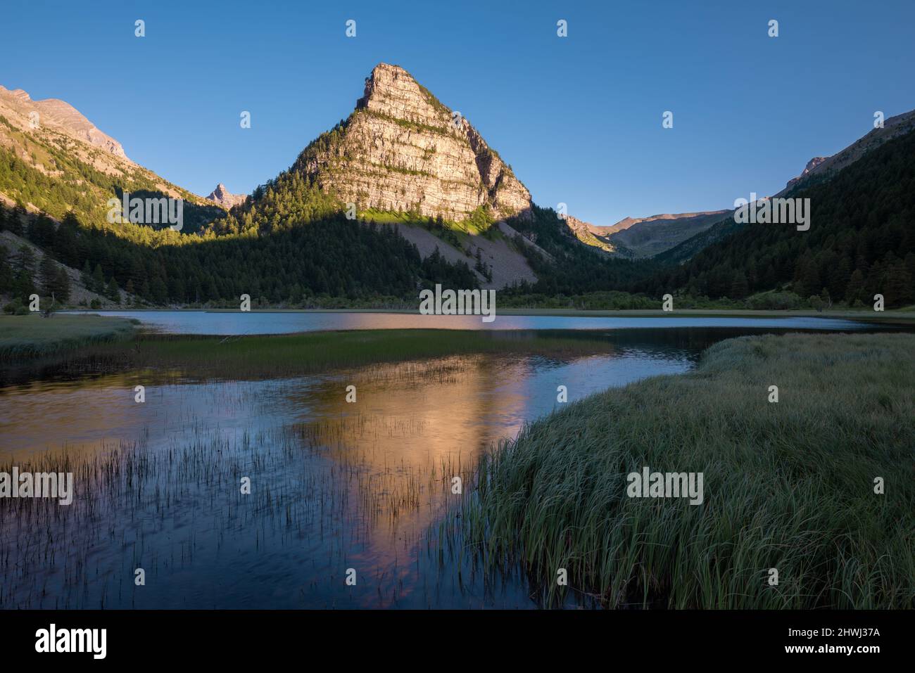 Sunset on La Tour des Sagnes pyramid shaped mountain with Lac des Sagnes in Summer. Ubaye Valley in Mercantour National Park. Alps, France Stock Photo