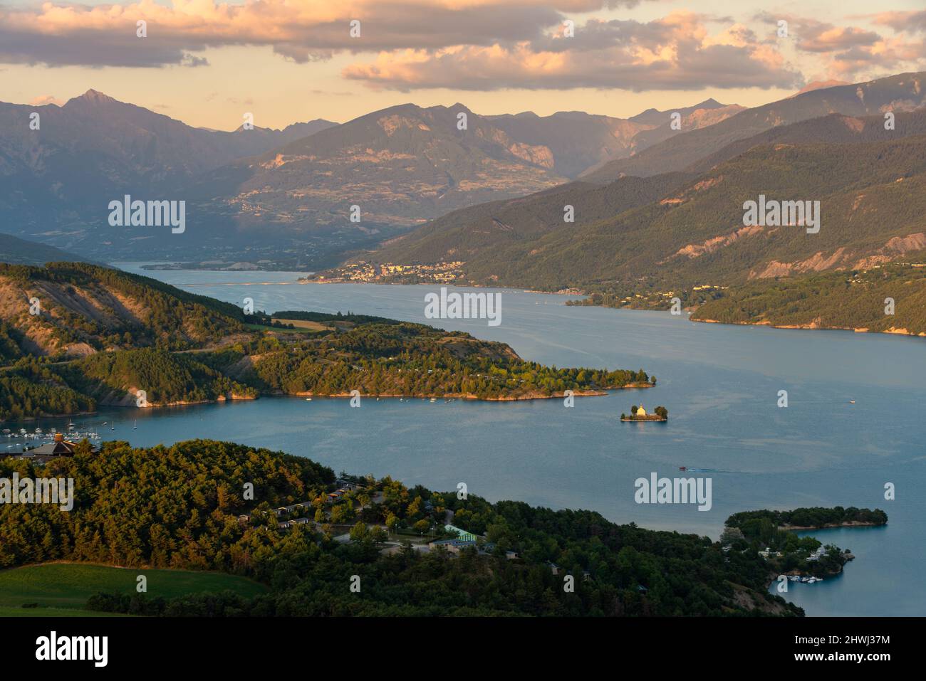 Serre-Poncon lake in the Hautes-Alpes (Alps). Sunset light on the village of Savines-le-Lac and Saint-Michel Bay. France Stock Photo