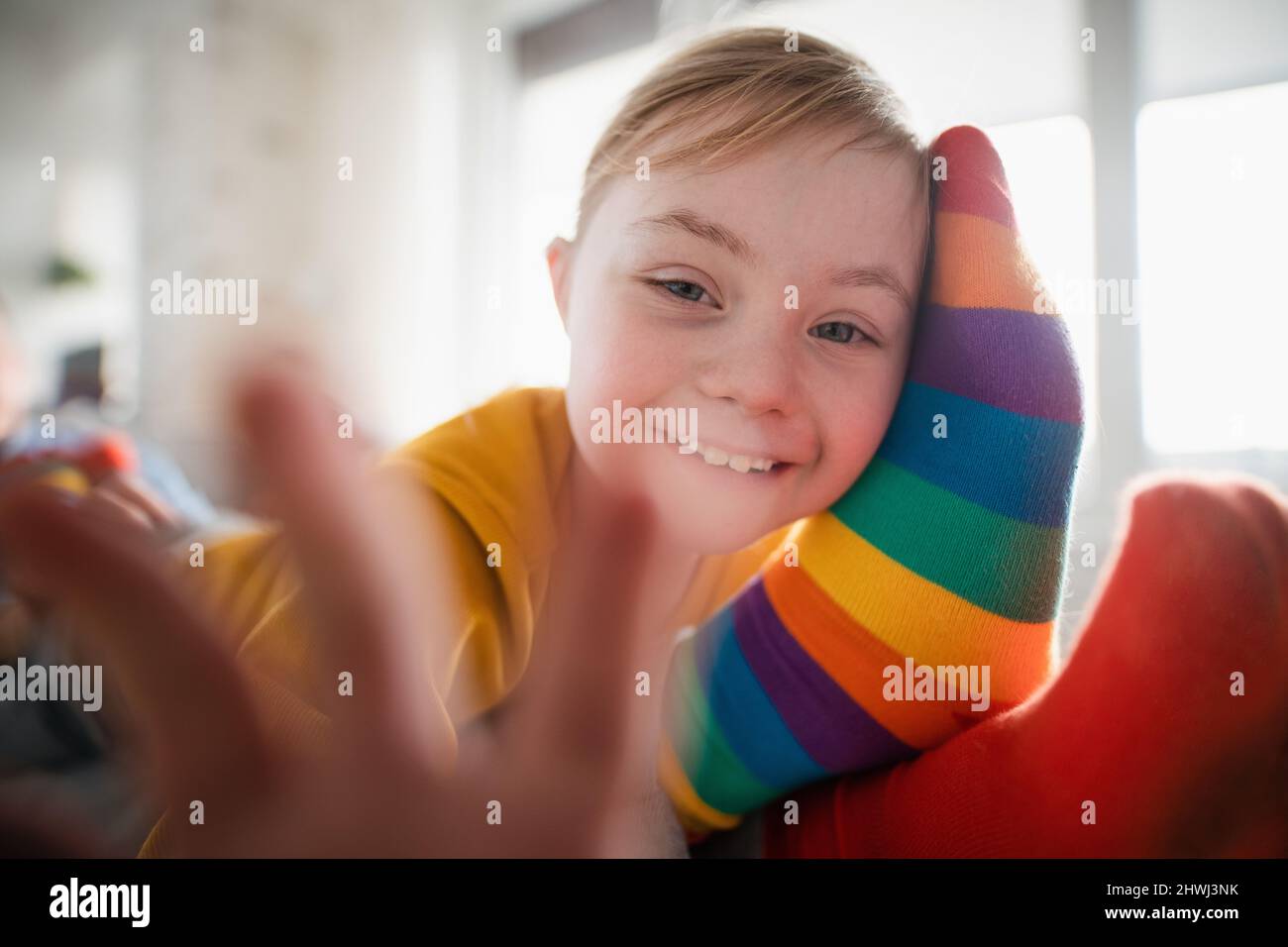 Closeup of cheerful little girl with Down syndrome lying on her father
