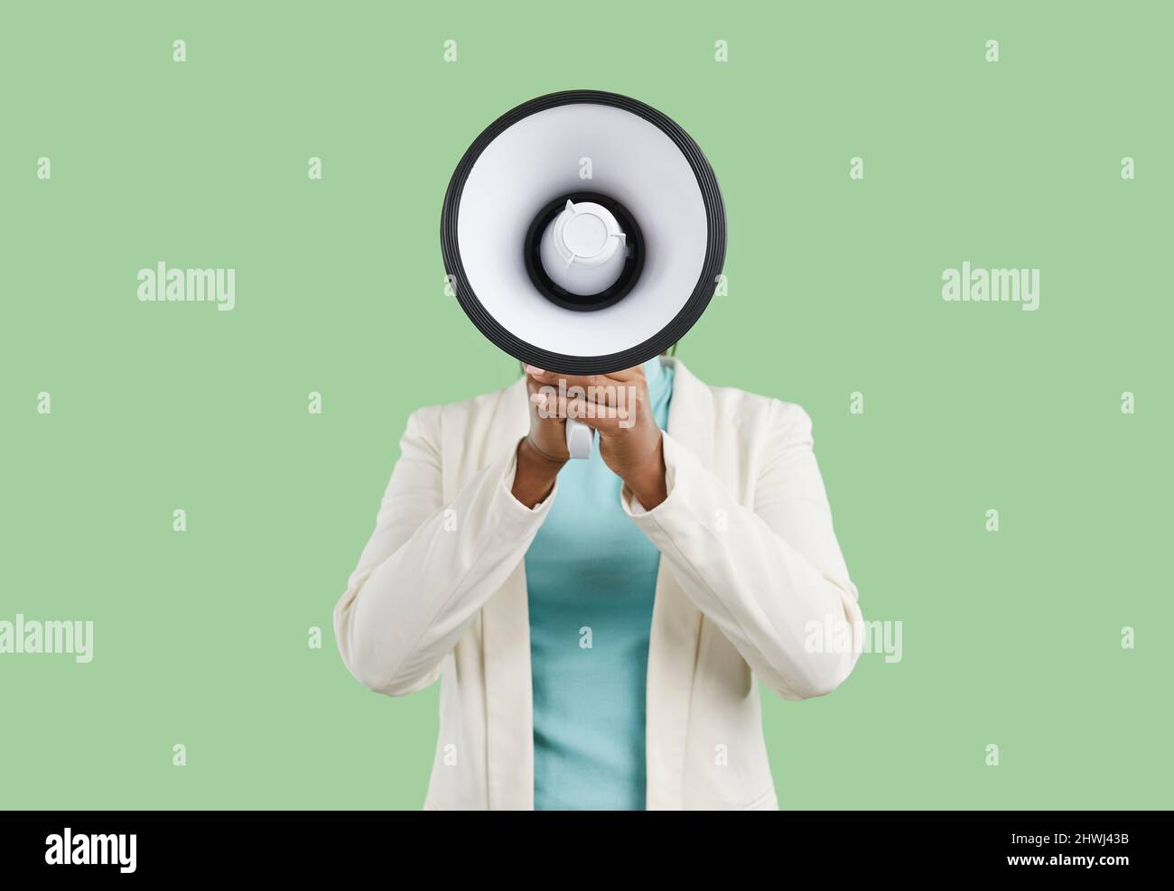 Black woman shouting through megaphone and making announcement with her loud voice Stock Photo