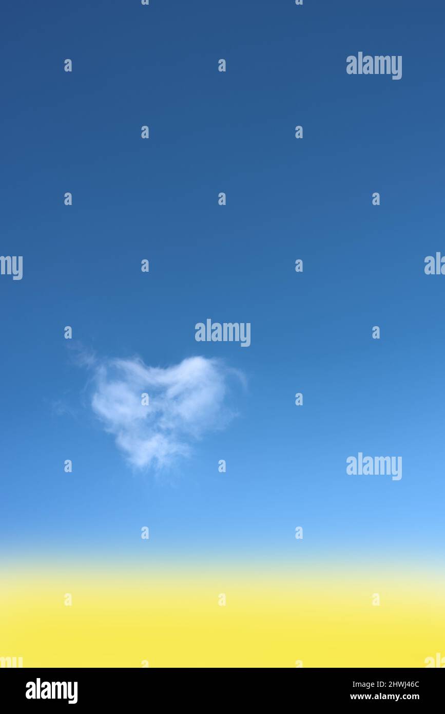 Heart shaped cloud on bright blue sky. Stock Photo