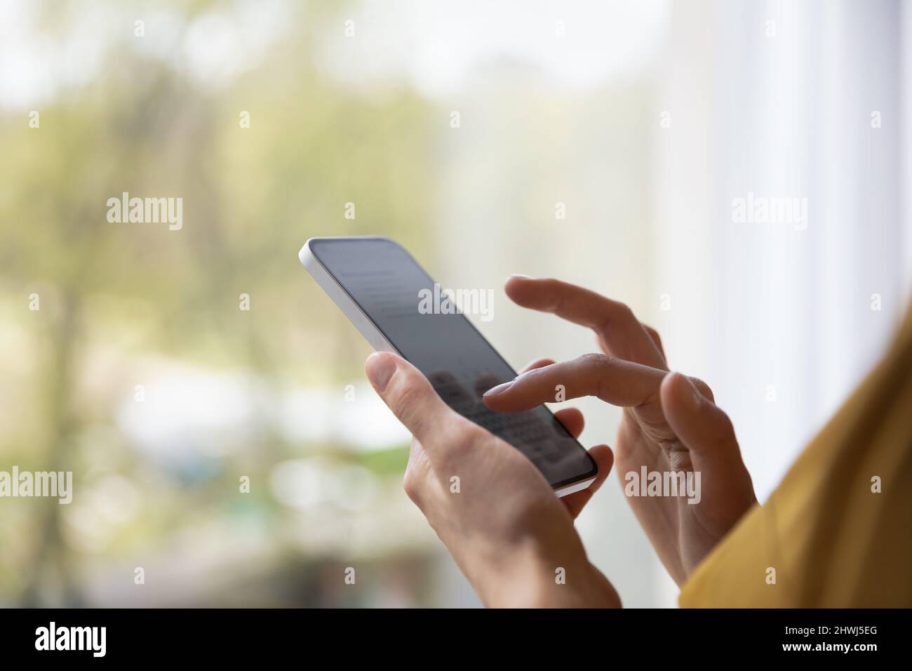 Closeup cropped view woman holds modern smartphone share text messages ...