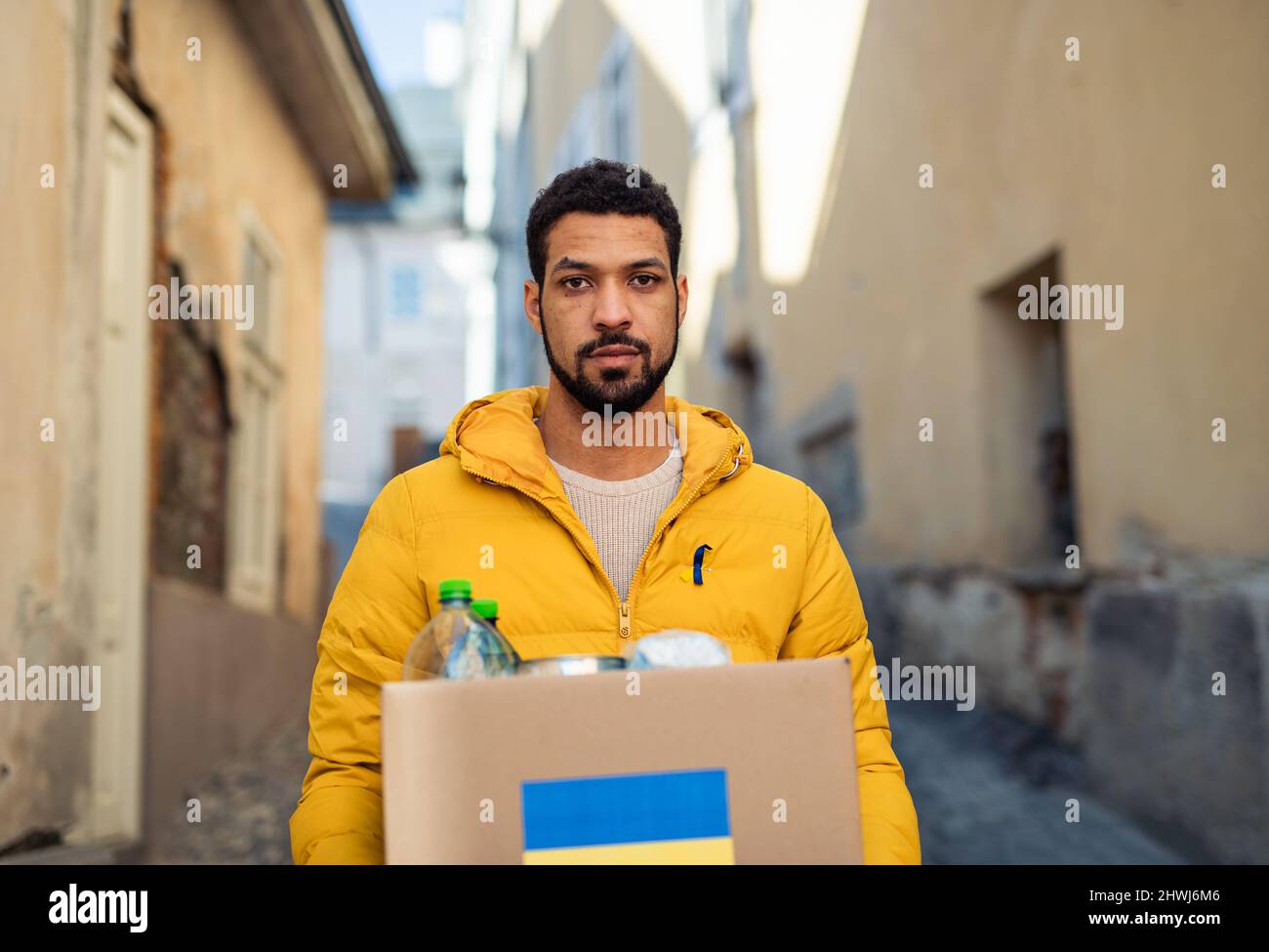 Volunteer cyrrying box with Humanitarian aid for Ukrainian refugees in street Stock Photo