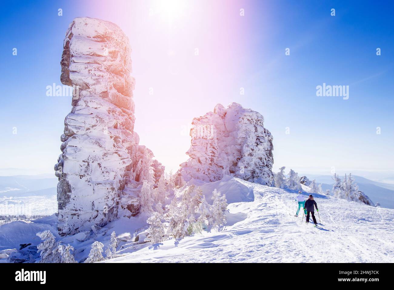 Winter skiing in snow, couple skiers downhill at ski slope, blue sky ...