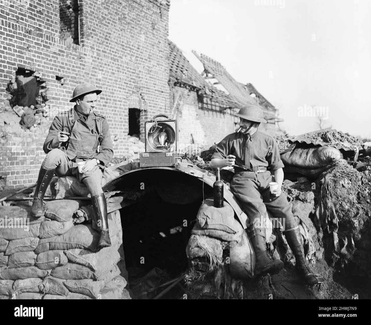 British officers enjoying a drink of alcohol and music from a gramophone outside their elephant-back shelter at Givenchy, 28 January 1918. Note the tambourine next to the gramophone. Stock Photo