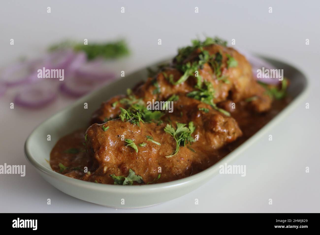 Chicken curry prepared by chicken in cashew gravy garnished with fresh