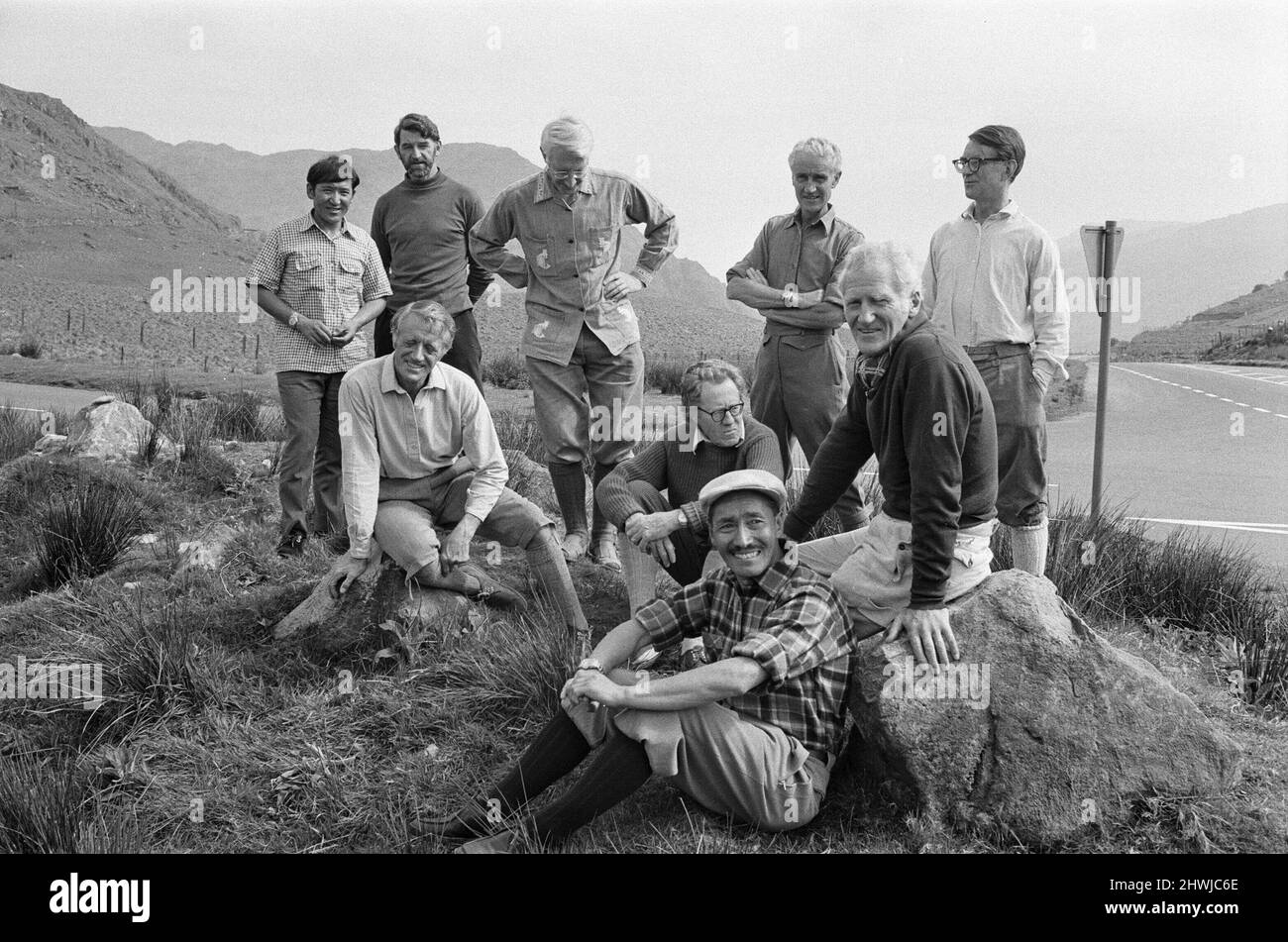 Everest Men reunion at The Pen-y-Grwd Training base at Capel Curig, North Wales.  26th May 1973 It is 20 years on from the 1953 Everest Climb, with this reunion in Wales in May 1973  Picture features : Lord Hunt, ( white hair, dark top, sitting on rock to the right). Sherpa Tensing Norgay (Sherpa Tenzing Norgay) is in the chequered shirt and cap sitting on the ground in the forefront ), far left, standing at the back, hands together is Sherpa Gombu, the man who has been to Everest Twice.The other men here are no id'd Note, Sir Edmund Hillary was not able to make this reunion.  Picture taken 26 Stock Photo