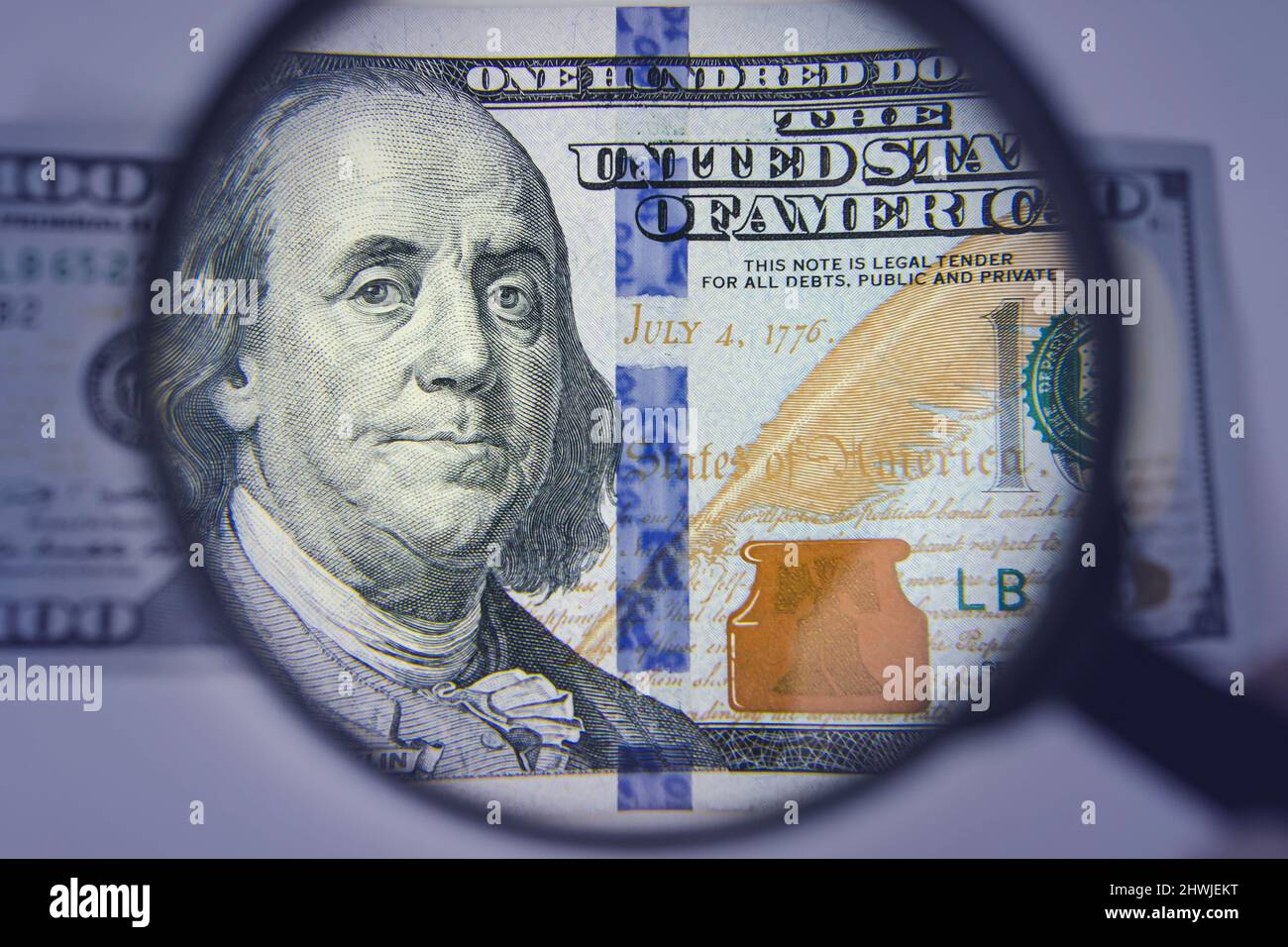 Finance and business. Hundred dollars banknote authentication. Magnifying Glass - 100 US Dollars Stock Photo