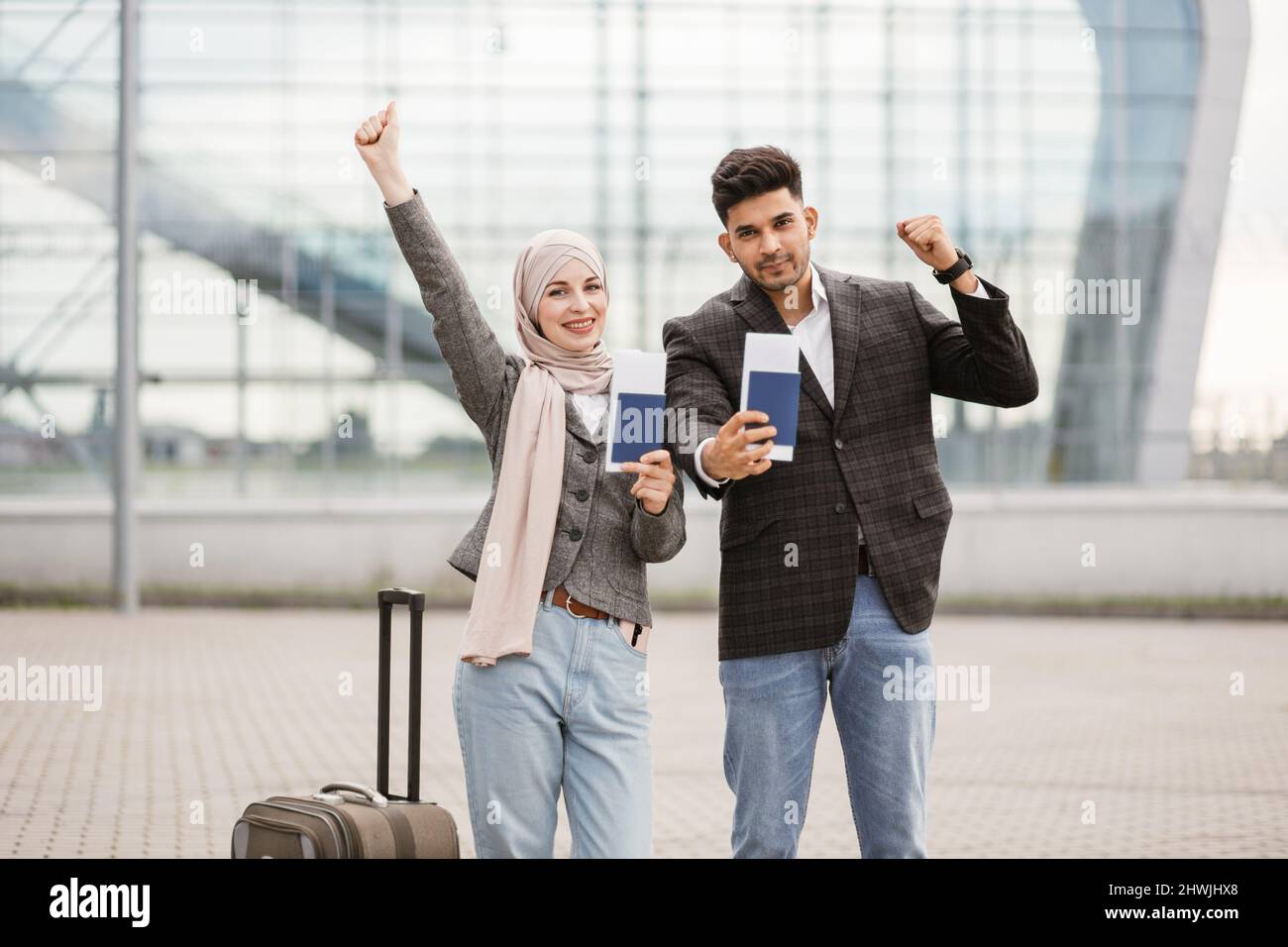 Smiling Muslim woman in hijab and Arab man, posing on camera outside ...