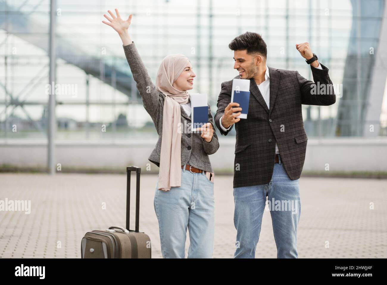 Smiling Muslim woman in hijab and Arab man, posing on camera outside ...