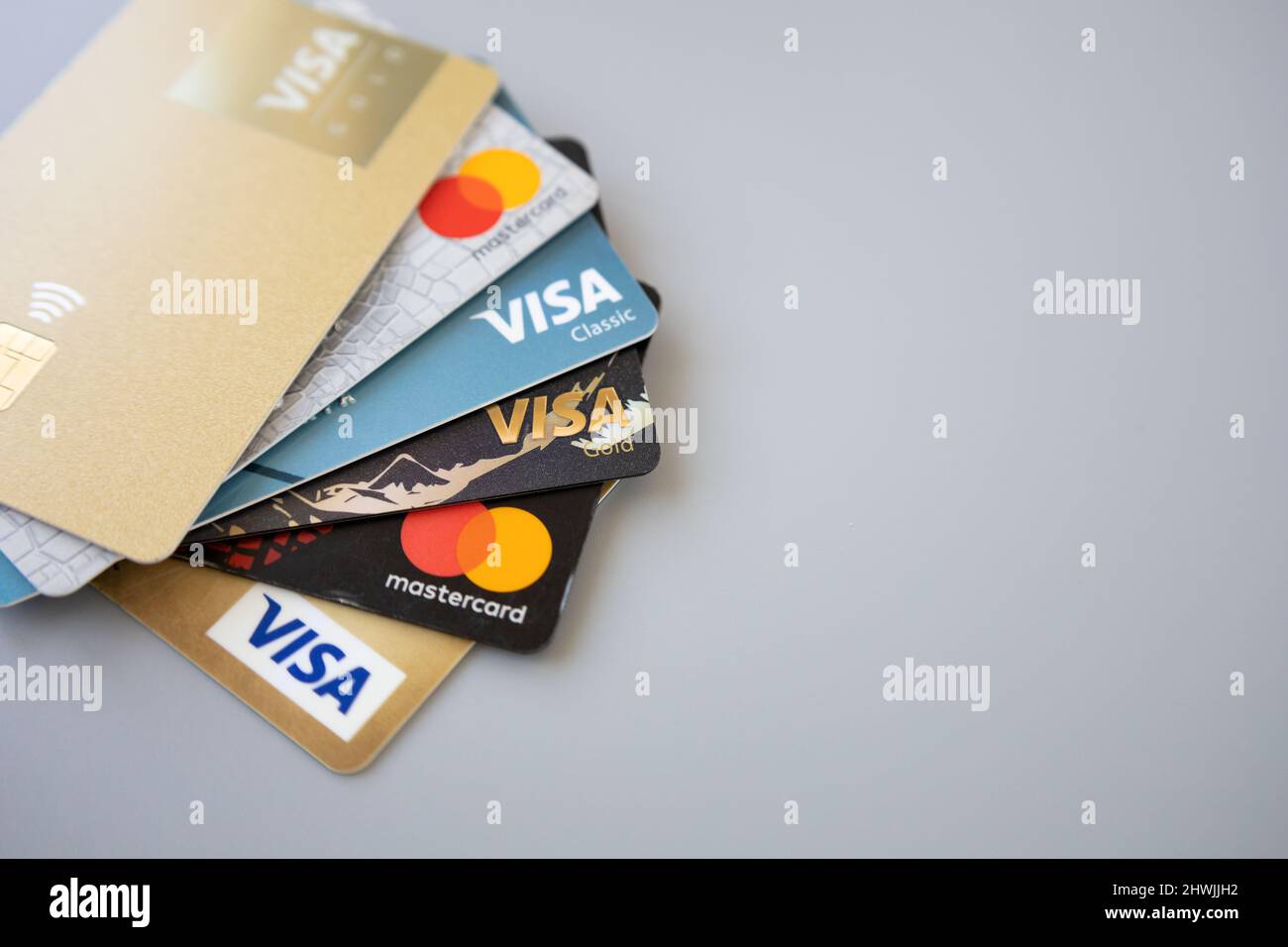 Minsk, Belarus 06 March 2022. Pile of Mastercard and Visa cards on grey background. Online credit card payment for purchases from online shopping Stock Photo