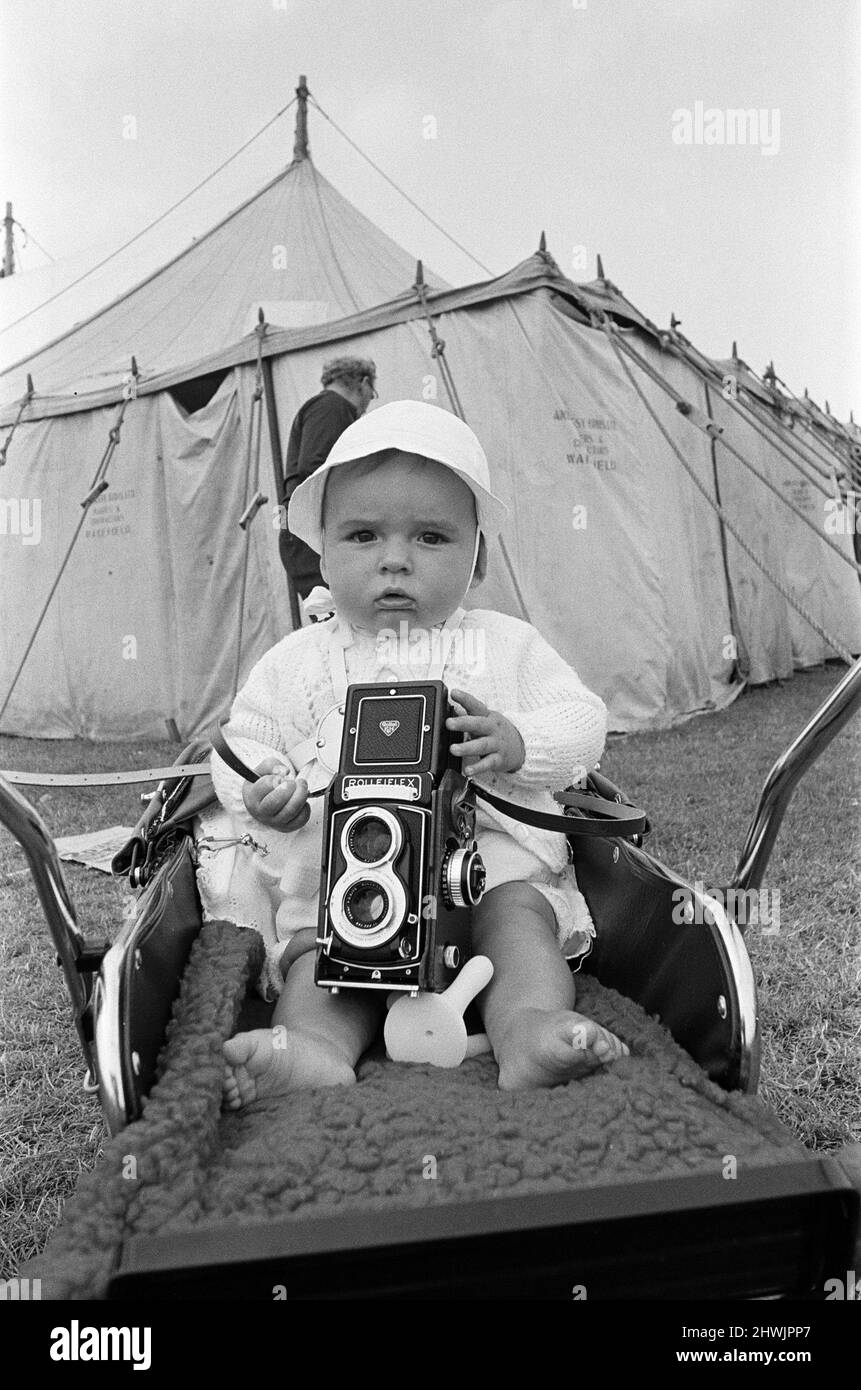 A baby sitting with a Rolleiflex camera at Skelton annual baby show. Circa 1973. Stock Photo