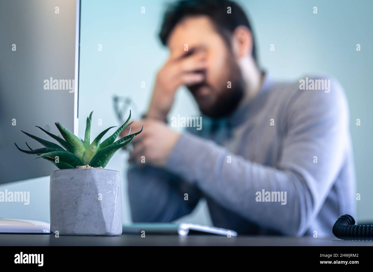 A tired man rubs his eyes in front of a computer screen Stock Photo - Alamy