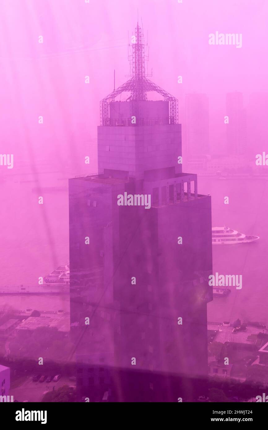 Building seen through magenta glass in foggy weather. Shanghai, China Stock Photo