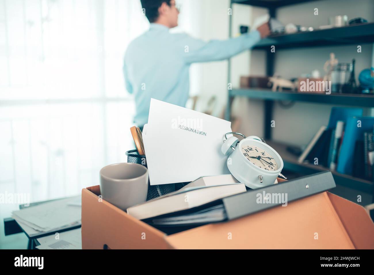 cardboard box and resignation letter, dossier, alam clock, coffee cup ...