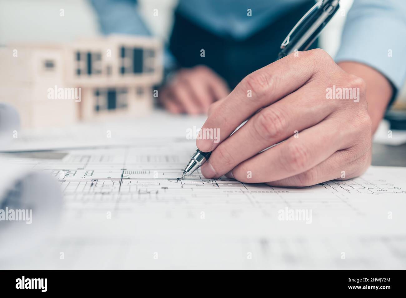 Architect engineer use pen drawing design working on bueprint. House